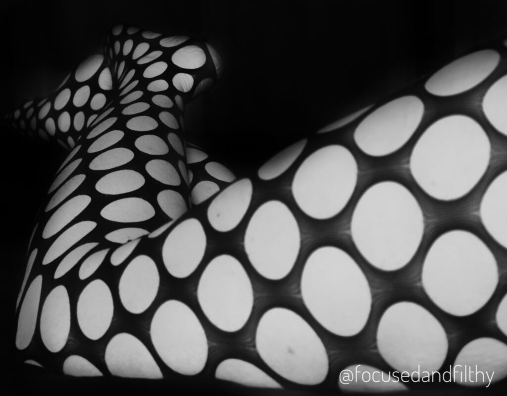 Black and white image of my legs in large fishnet bodystocking. 